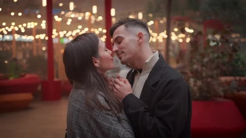 Happy Romantic Couple Rubbing Noses on Street at Christmas Night