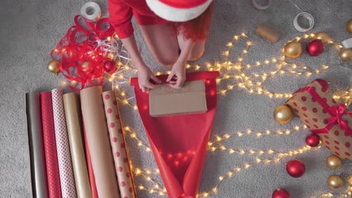 Woman Wraps Christmas Present on Lit Carpet