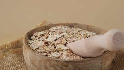 Bowl of Rolled Oats with Wooden Scoop