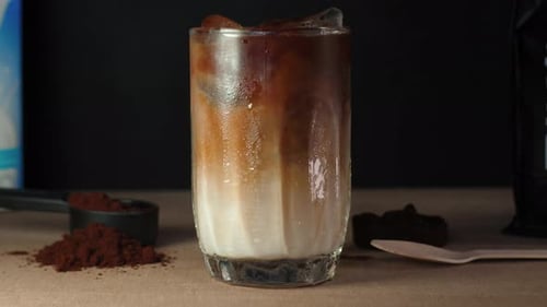 In einem so kalten und hohen Glas beginnen cremige Milch und leckerer Kaffee zu fallen