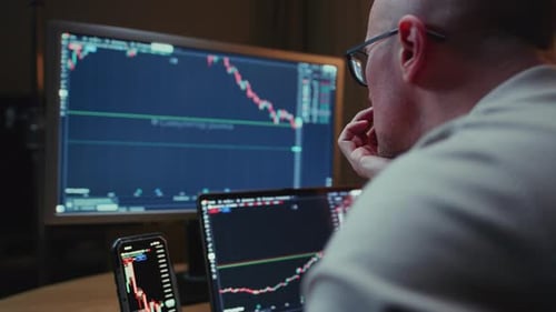 Man in Trader Home Office Monitor and Laptop are on Table Trading Program or Exchange Male Analyzes