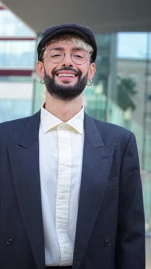 Portrait individuel vertical d'un homme branché souriant et regardant la caméra debout à l'extérieur