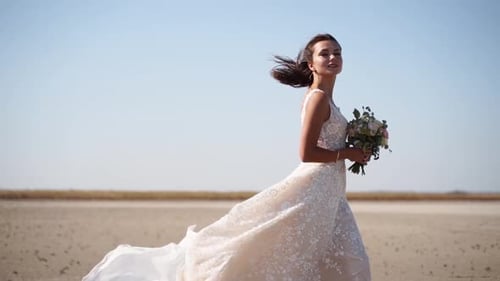 Happy Young Bride with Bouquet of Fresh Flowers Going at the Dry Lake Elegance Lady in Gorgeous