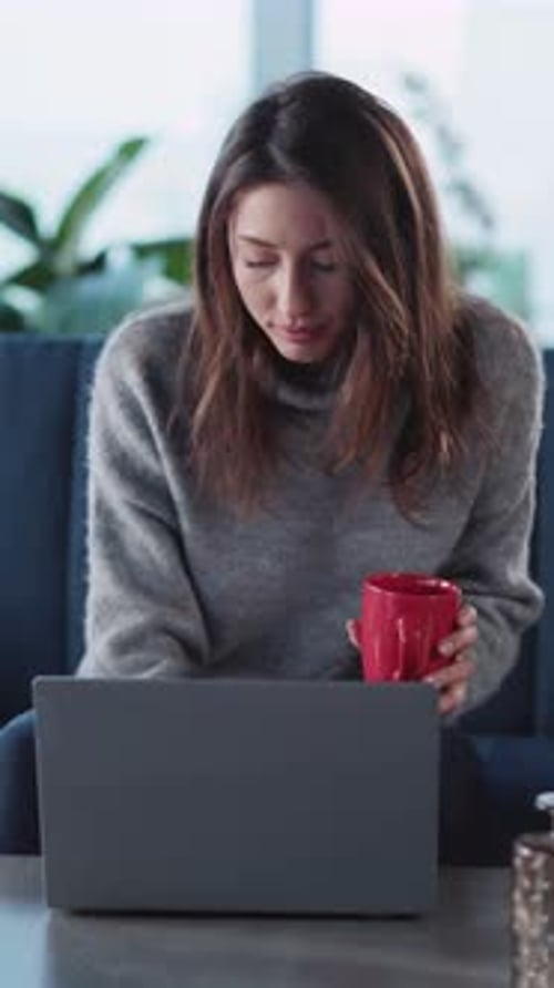 Woman Works on Laptop at Home with Coffee