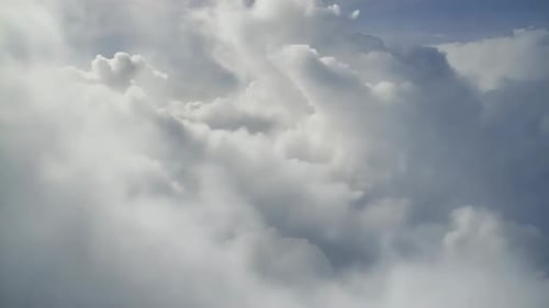 Vol aérien à travers des nuages blancs duveteux sous un soleil éclatant