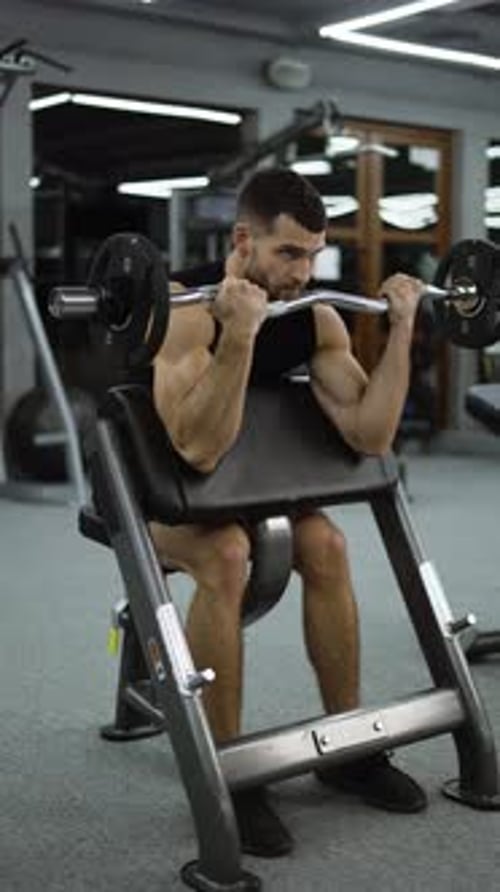 Handsome Bodybuilder Doing Weight Lifting in Gym