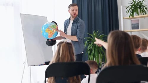 Man holding globe. Group of children students in class at school with teacher