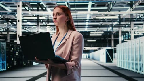 Woman in Modern High Tech Server Hub Using Notebook to Do Maintenance