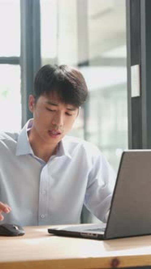 Young Adult Using Laptop in Bright Workplace