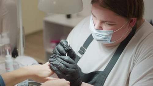 Manicurist Using Wooden Tool in Nail Salon