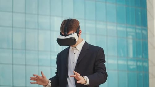 Male Engineer Wearing Virtual Reality Headset Works and Gestures in VR