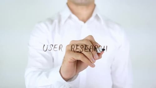 Hand Writes User Research on Clear Screen