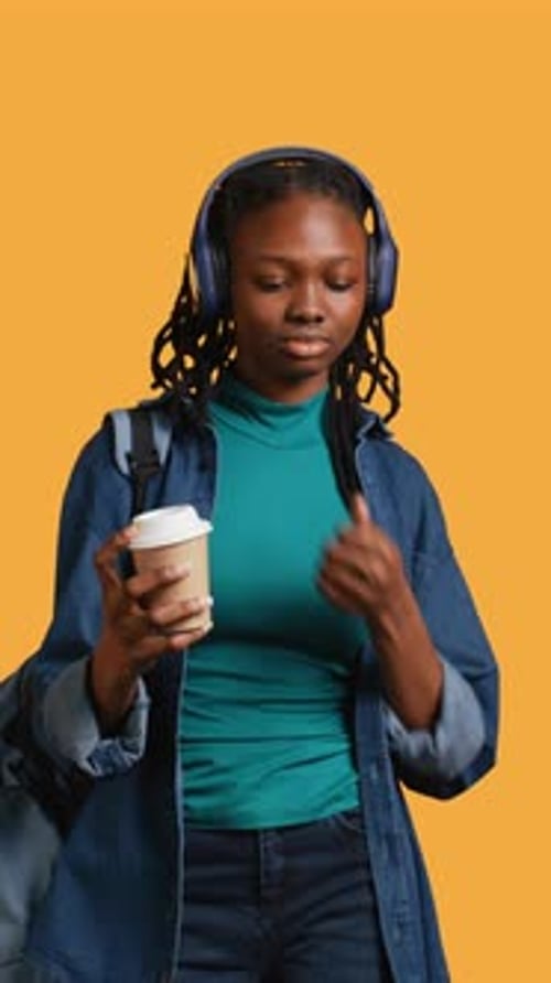 Vertical Video Girl with Backpack and Headphones Yawning Feeling Tired Studio Background