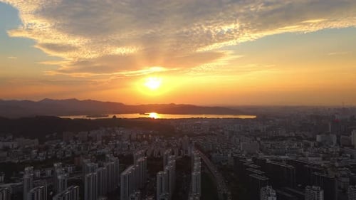 Aerial View of Sunset Over Cityscape and Lake in Vibrant Skyline