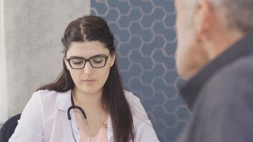 The doctor is listening to her patient in the hospital and asking questions.