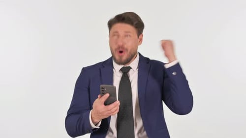 Man in Suit Celebrates While Looking at Phone
