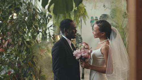 Loving Wedding Couple Embrace in Indoor Garden Setting