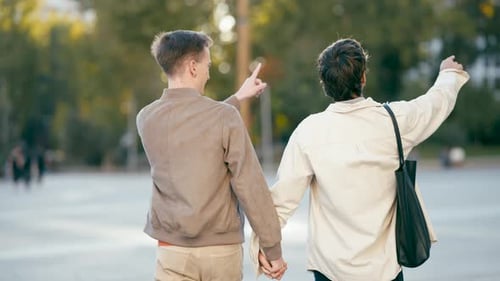 Romantic Gay Couple Walking Hand in Hand in a City Park