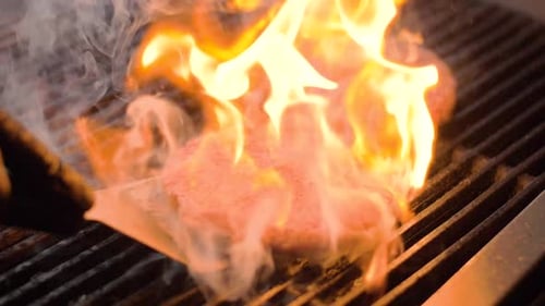 Chef Cooking Beef Patty for Burger on Hot Grill and Flip the Cutlet with a Spatula
