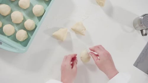 Hands Shaping Dough Balls on White Countertop