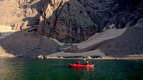 Kayakers Paddle on Mountain Lake Adventure
