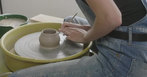 Un potier façonne de l'argile dans un produit au moulin à poterie.