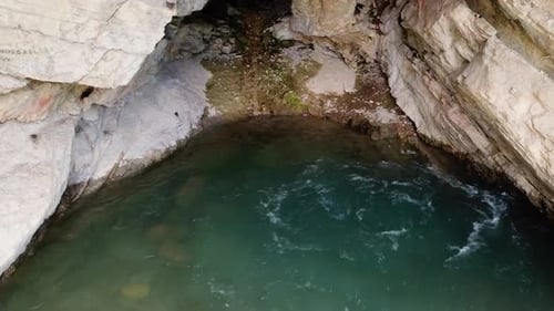 Bubbling water is seen flowing from a cavern. (slow motion)