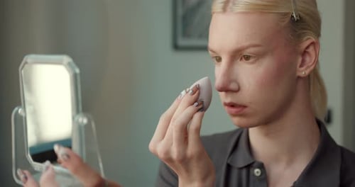 Young Adult Applying Makeup Indoors at Home