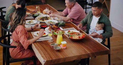 Family Eating Meal Together at Wooden Table