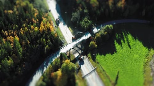 Une photo prise par un Drone montre un site de déconstruction sur une route traversant une forêt et un feu vert adjacent