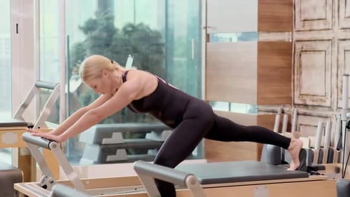 Woman Working Out on Pilates Machine in Gym