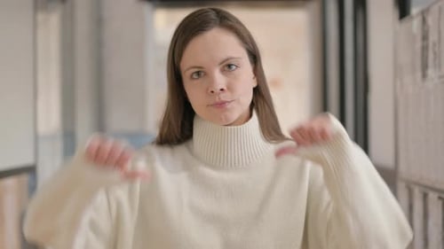Woman Gesturing Thumbs Down Indoors