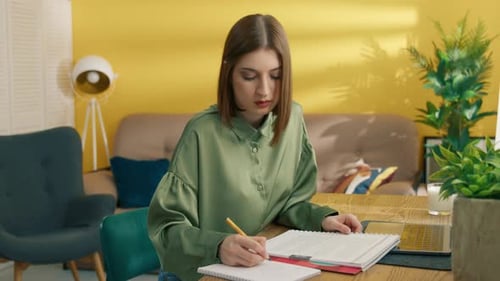 Woman Studying and Writing at Home at a Table
