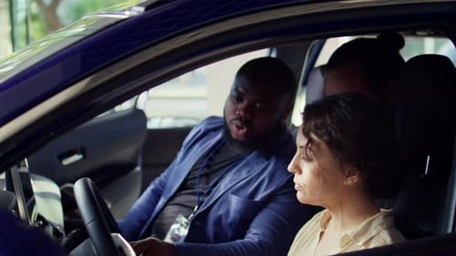 Salesman Discussing with Clients Doing Test Drive Before Buying Car