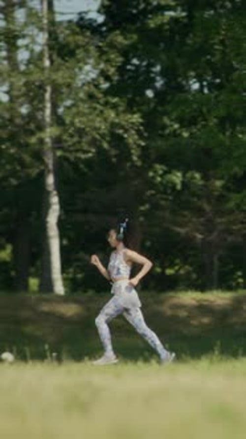 Young Woman Running in Park on Summer Day