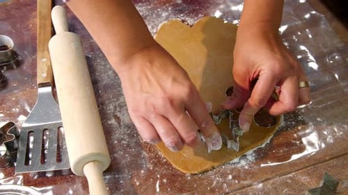Cookie Cutter Shapes Being Cut From Cookie Dough