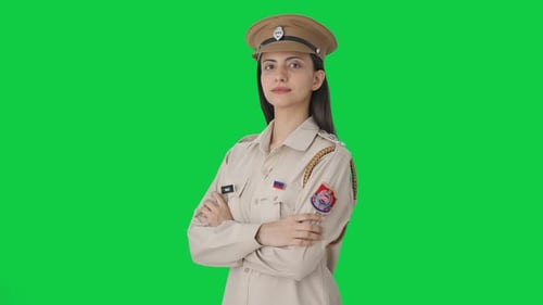 Portrait of Indian female police officer standing crossed hands Green screen