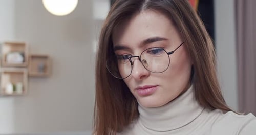 Nahaufnahme einer schönen jungen kaukasischen Freiberuflerin oder Studentin drinnen hübsche Frau mit Gesicht in