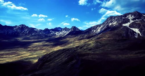 Vast Mountain Landscape with Dramatic Sky and Sunlight Illuminating Terrain