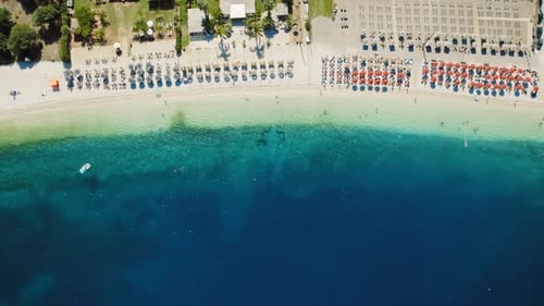 Aerial view of an organized beach with sunbeds and umbrellas on a sunny day