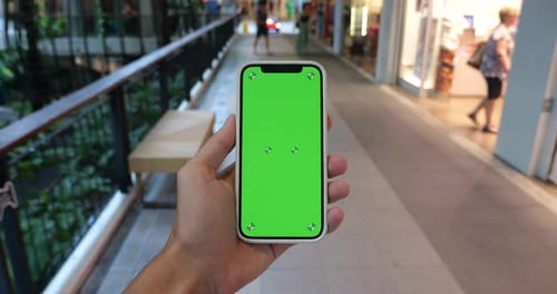 Männliche Hand hält ein Smartphone vertikal mit Kopierraum zum Einfügen eines Werbepräsentationsvideos