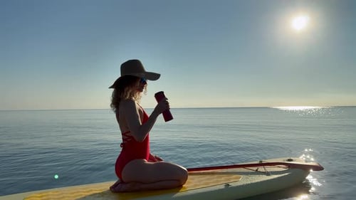 Young woman walking on stand up paddle sup boards by the sea during summer vacation