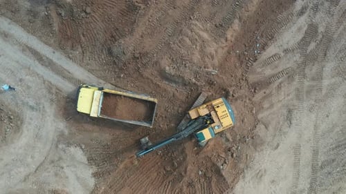 Excavator Loads Soil into Dump Truck, Aerial View