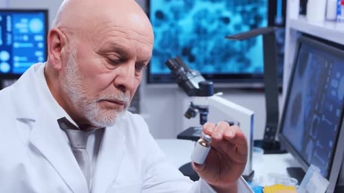 Senior Scientist Examining Vial in Laboratory Setting