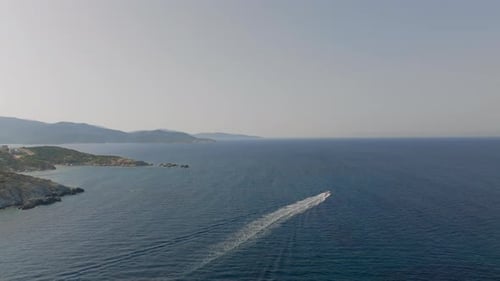 Cinematic Drone Advances Over Serene Blue Waters Capturing a Speedboat Trail
