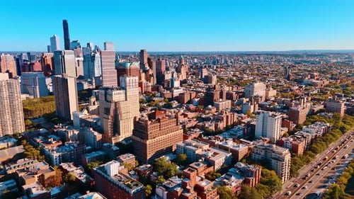 Vast panorama of New York on sunny day from drone. Flow of cars moves by the roads of the city.
