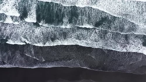 Slow Motion Aerial Above View of Atlantic Ocean Waves Washing Volcanic Black Sandy Beach, Iceland