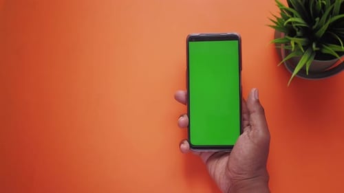 Top View of Young Man Hand Using Smart Phone with Green Screen