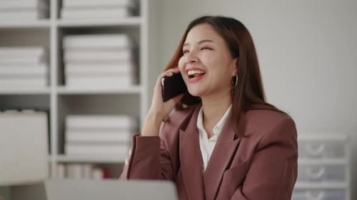 Cheerful Businesswoman Talking on Phone in Modern Office