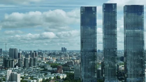Three Skyscrapers Towering Over Moscow Cityscape Under Cloudy Sky